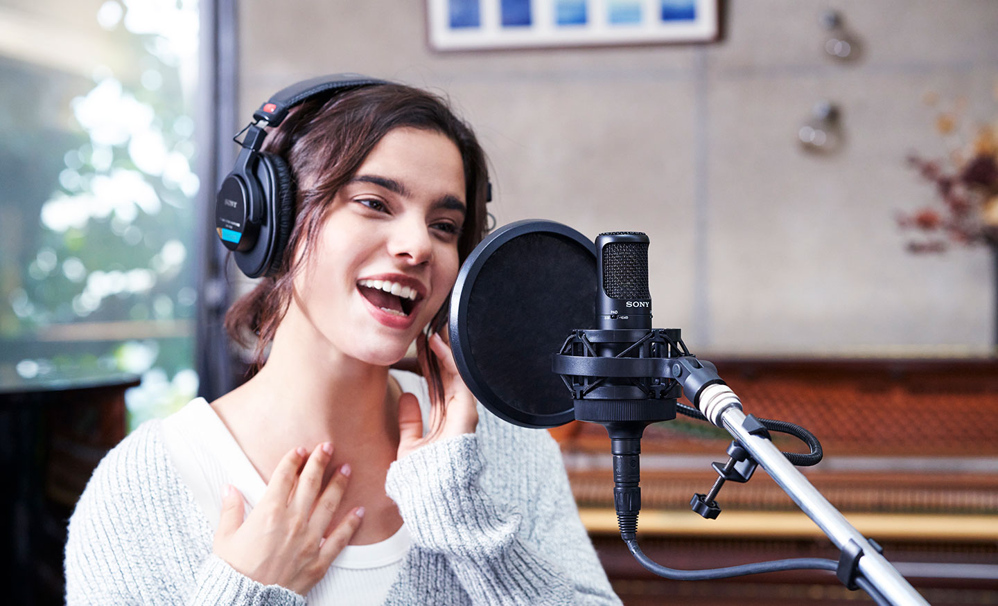  Image of a lady singing into a Sony C-80 Uni-directional condenser microphone with a pop shield in front of it