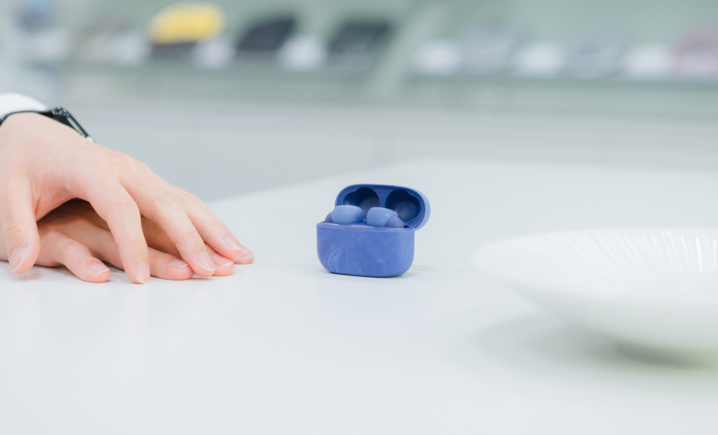 Des écouteurs dans un boîtier bleu sont posés sur la table