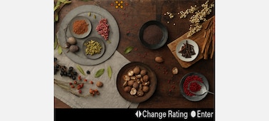 Image of food on a table as seen through the monitor, with a "Change Rating" control visible