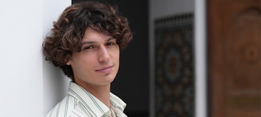 Example image of a male model smiling towards the camera with bokeh background