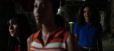 Example image of three women in the dark with the furthest from the camera in sharp focus, demonstrating precise subject tracking