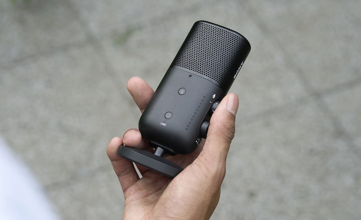 Product image of a person holding the microphone with one hand