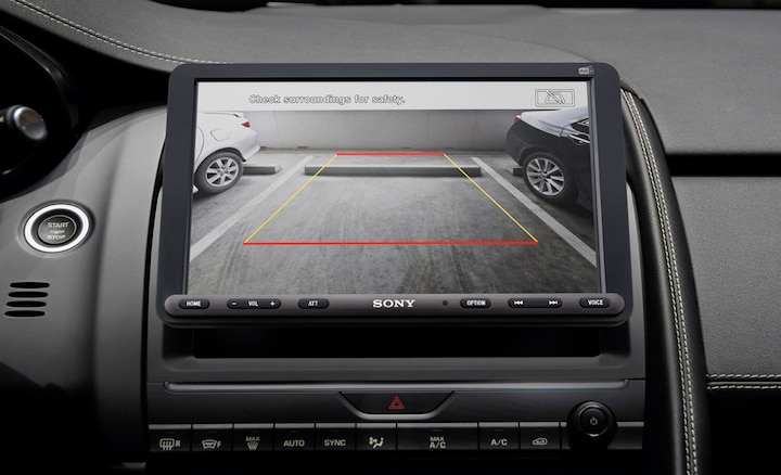 Image of the 8.95" (22.7cm) Digital Media Receiver with WebLink Cast inside a car with a driver using the rear view camera.