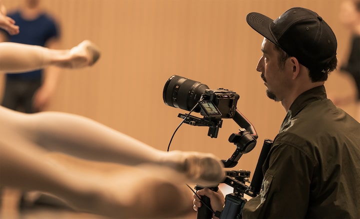 Usage image showing a photographer shooting a ballet rehearsal with a camera mounted on a gimbal