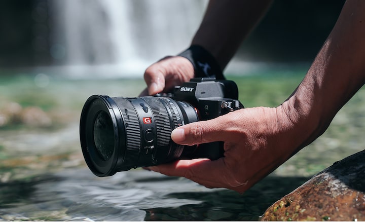 Close up image of a person shooting by the water.